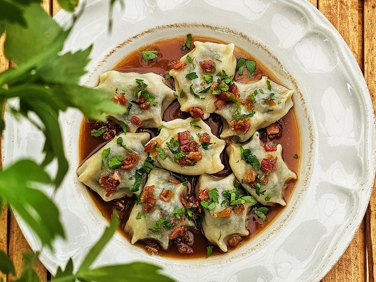 Pierogi in broth with crispy bacon and parsley